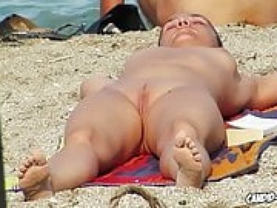 Des nudistes chauds et excités s'amusant à la plage, espionnés par un voyeur.